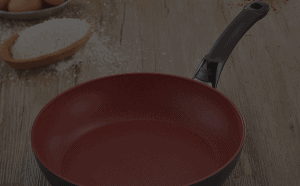 photo showing look of red cast iron frypan on a timber kitchen bench