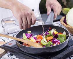 cooking stir fry vegetables on a portable cooktop