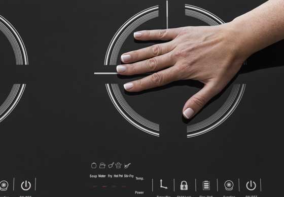 hand on a double induction cooktop showing how safe it is to use