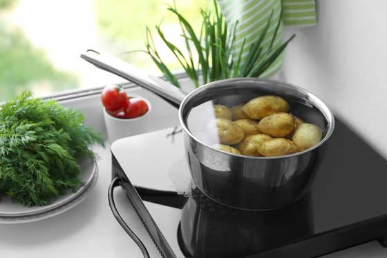 potatoes boiling on a single portable induction cooktop